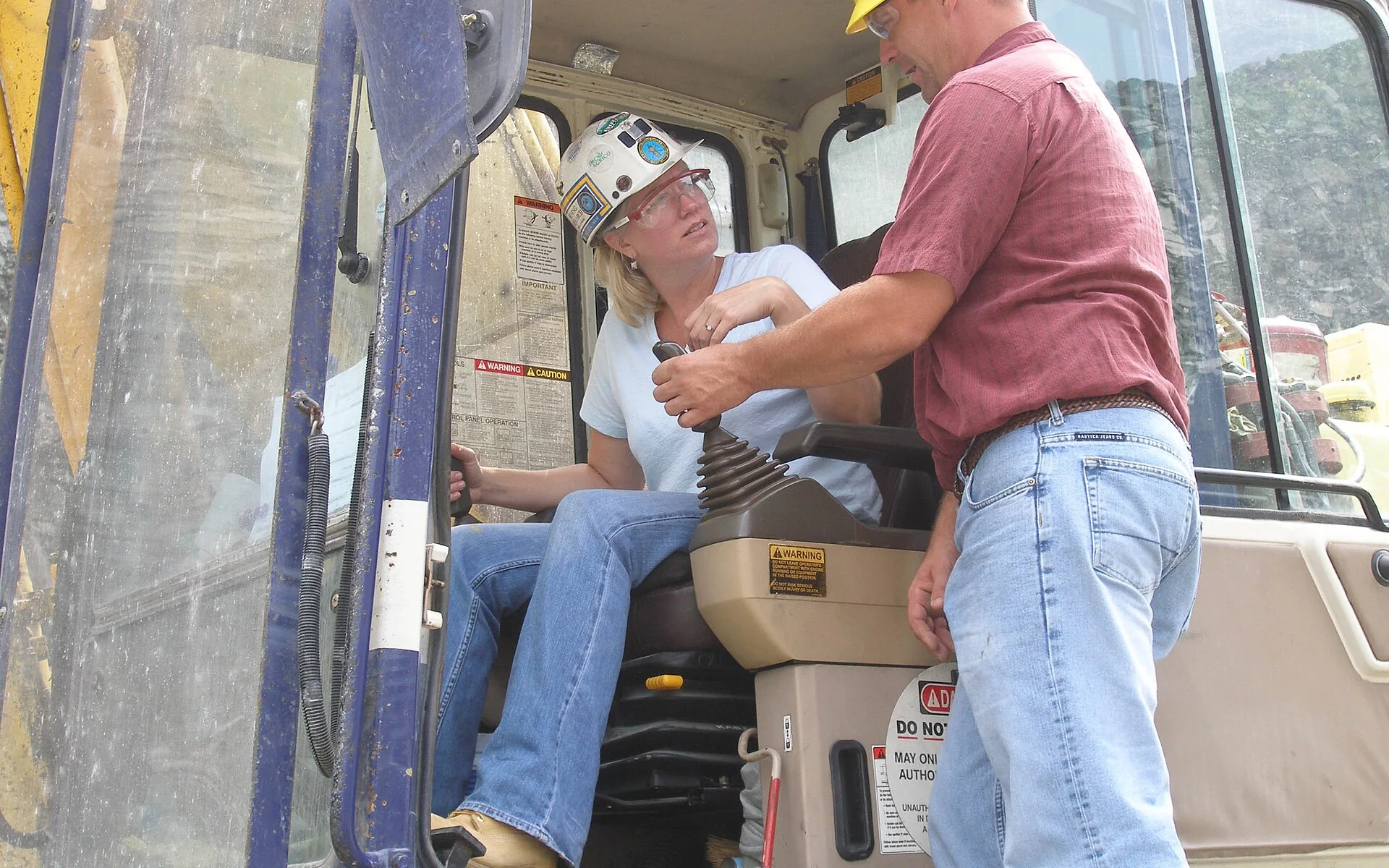 Workers discussing safety beside heavy equipment